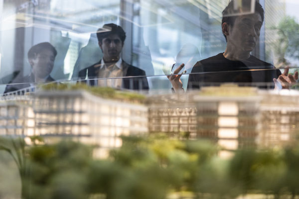 three people overlooking city model